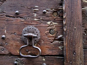 close up of an old wooden door with a knocker